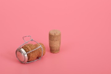 Champagne and wine cork isolated on pink (coral) background