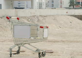 An abandoned metal shopping trolly cart in dusty dubai, discarded and left in the sparse desert dust. Abandoned in dubai.