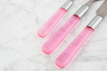 Two spoons and knife on white gray background.