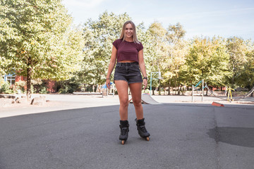 Glückliches sportliches Mädchen fährt Inline Skates
