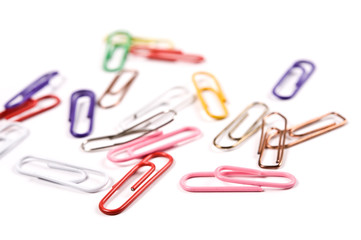 Close-up of multi-colored paper clips on a white background.	