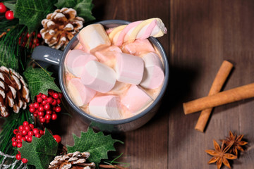  marshmallow in grey cup on brown wood background with Christmas tree ,  candles and christmas lights