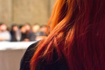 Red-haired woman. Strands of red hair witch. The girl with red hair. View from behind the girl....