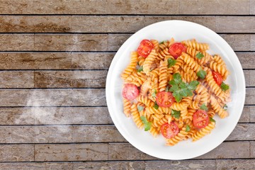 Spaghetti pasta with tomatoes and parsley on  table.