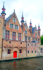 Streets of Bruges in Belgium with its medieval style facades on a cloudy day.