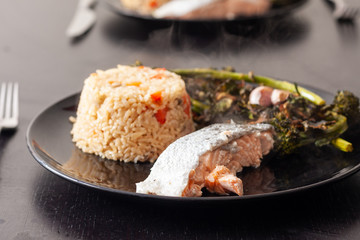 Salmon fillet served with brown rice and roasted tenderstem broccoli