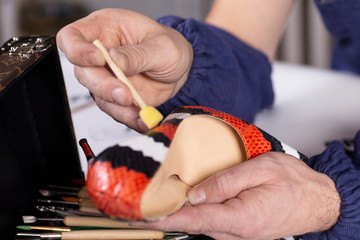 Shoemaker repair female spike shoe. Hands and Shoe close-up.
