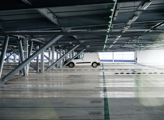 Small white van parked in modern airport parking