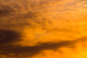 Fototapeta na wymiar Airplane is landing during a nice cloudy sunrise.