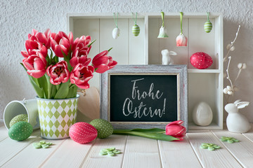 Springtime background with Easter decorations, tulips and a chalk board with text