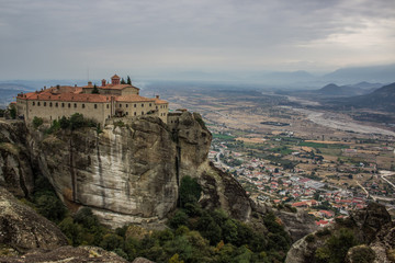 Fototapeta na wymiar christian religion lonely monastery on top of steep rock on dramatic cloudy country side landmark landscape background view