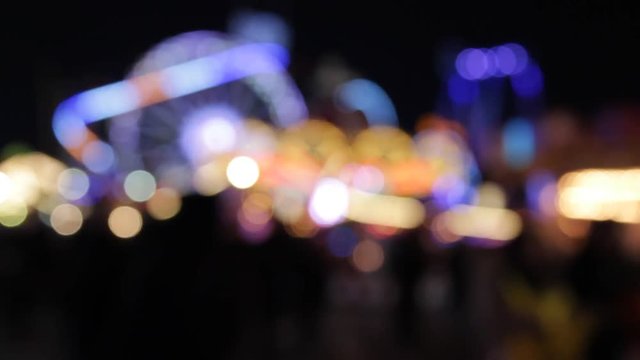 funfair fairground ride rainbow bokeh lights rides moving flashing people at night