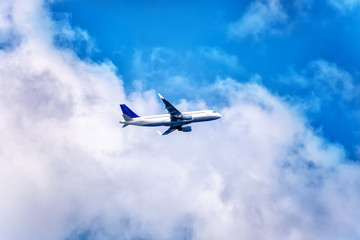 Fototapeta na wymiar Big jet flying on background of cloudy blue sky.