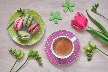 Spring coffee background. Macarons, espresso in pink cup, freesias and pink tulips