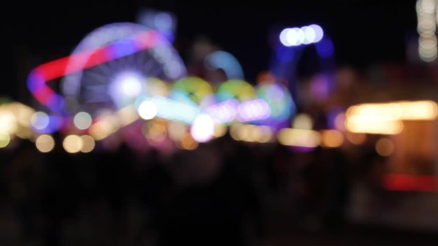 funfair fairground ride rainbow bokeh lights rides moving flashing people at night