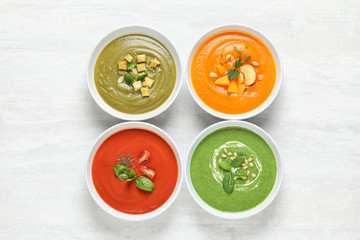 Various soups in bowls on white background, top view. Healthy food