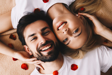 Couple. Love. Valentine's day. Emotions. Portrait of man and woman lying and smiling; top view
