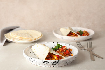 Chili con carne served with tortilla on table