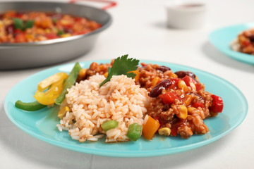 Chili con carne served with rice on table