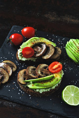 Beautifully served appetizing avocado toasts with mushrooms.