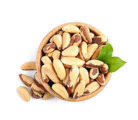 Brazil nuts in wooden bowl on white background, top view