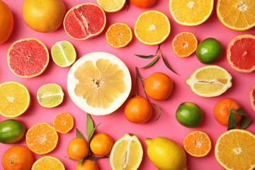 Different citrus fruits on color background, top view