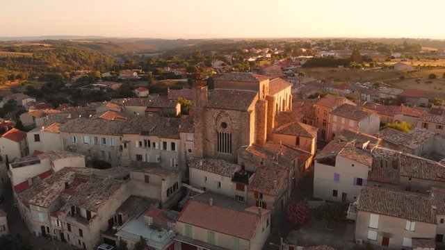 Aerial footage of flying around an 11th century old french provence church during sunset in Valensole