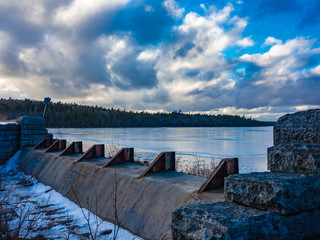 Water dam at sunset near frozen lake in winter, Nova Scotia, Long Lake, Canada.