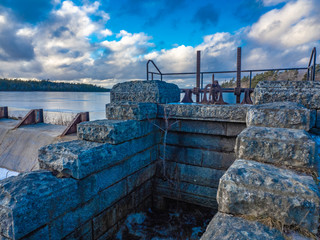 Obraz premium Stone gate for water flow, river in winter.