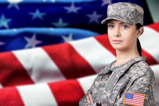 Portrait Of Female US Army Soldier On Flag Background