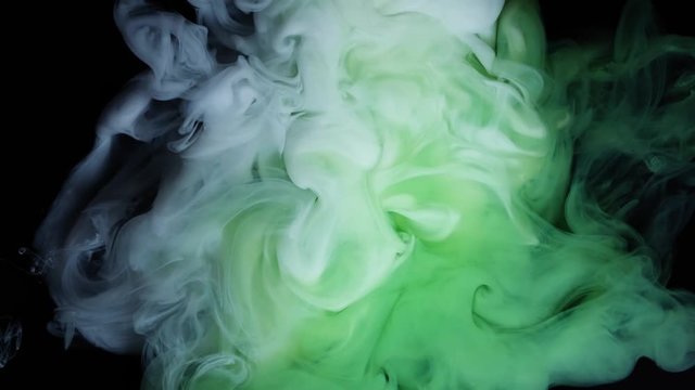 Green and white ink in water.Creative slow motion. On a black background.