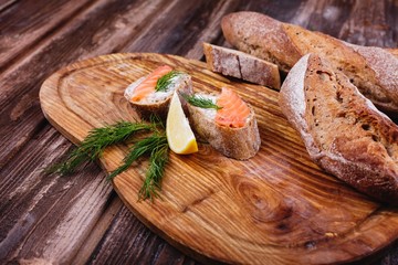 Fresh and healthy food. Snack or lunch ideas. Homemade bread with lemon and salmon served on wooden board