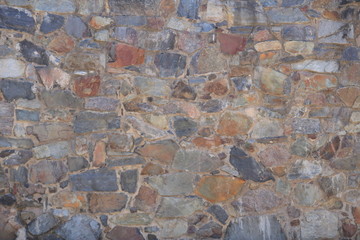 Close-up of rustic stone wall in color
