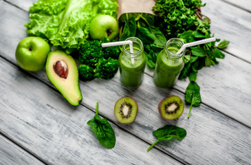 smoothie with vegetables, avocado, apple, kiwi on a wooden background. sports nutrition