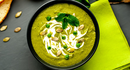 Green cream soup of spinach and broccoli. concrete or slate background. The concept of a healthy diet and diet.