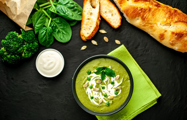 Green cream soup of spinach and broccoli. concrete or slate background. The concept of a healthy diet and diet.