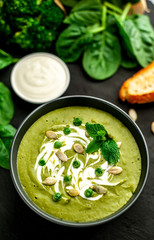 Green cream soup of spinach and broccoli. concrete or slate background. The concept of a healthy diet and diet.