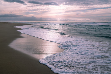 Sunset over the sea, beautiful sand beach and colorful sky, abstract seascape