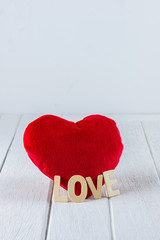 Valentines Day background with Red Heart shape and Wooden letters word "LOVE" on white wooden table