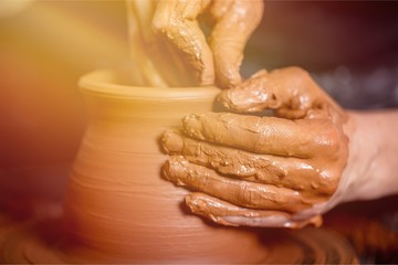 Hands of potter making clay pot, closeup photo