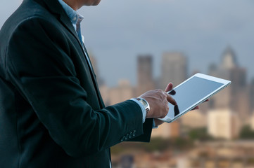Business man working on media pad with business building background. © aee_werawan