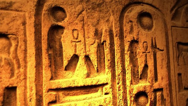 Ancient Egyptian Symbol of ten commandments or another object of ancient origin lit by candle