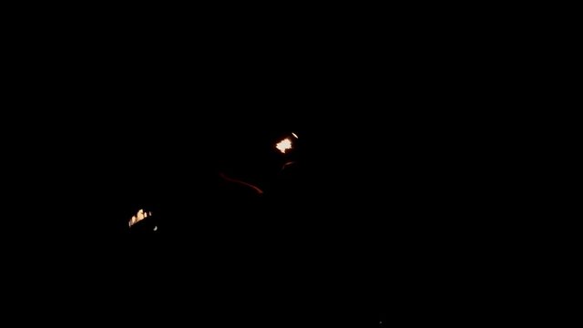 Coll fire show artists having a performance in the dark, swinging staff with burning ends, then breathing fire on it - extreme slow motion