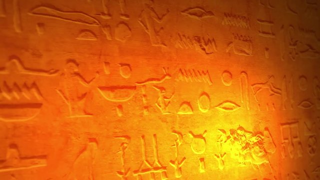 Ancient Egyptian lettering or language inside tomb of the pyramids lit by candle V2