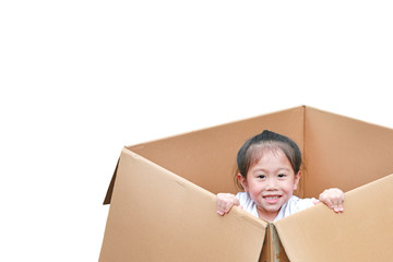 Happy little Asian child girl playing peekaboo and lie in big cardboard box.