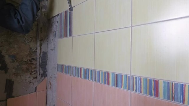 Demolition of old tiles with jackhammer. Renovation of old walls in the bathroom or kitchen