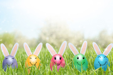 A row of Easter eggs with smiles in fresh green grass. A banner