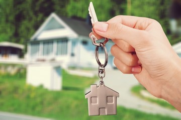 Hand Holding Metal House Key on white background