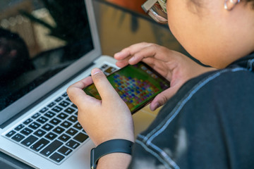 Asian teenager playing mobile games on smartphone
