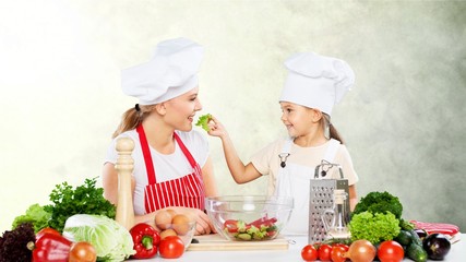 Cute little girl with vegetables in kitchen